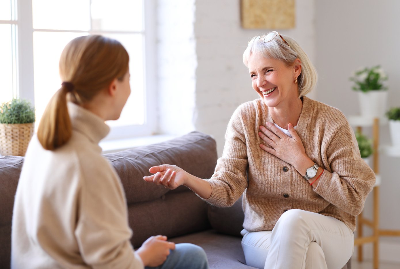 Happy women chatting on sofa at home