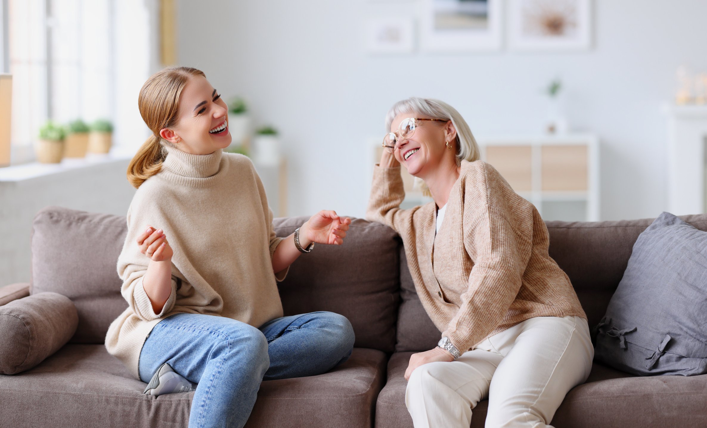 Happy women chatting on sofa at home